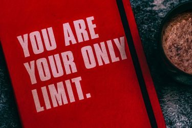 Czerwony welcome book z napisem You Are Your Only Limit
