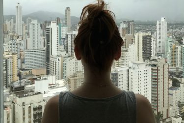 Młoda kobieta obserwująca panoramę wielkiego miasta - widok na biurowce.
