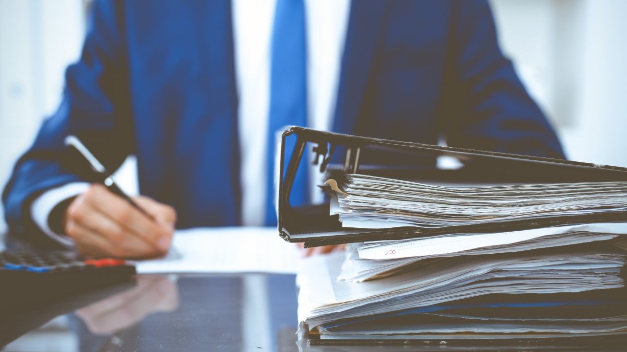 Biznesmen z dokumentacją: Kopia świadectwa pracy zamiast duplikatu. Jak złożyć wniosek o wydanie kopii świadectwa pracy