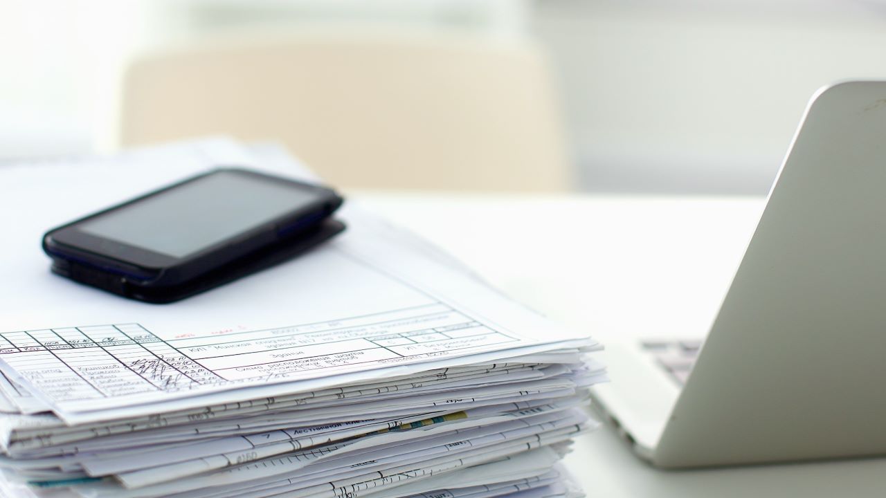 Dokumenty i telefon na biurku: Krajowa Infolinia Podatkowa – zobacz spis numerów i zakres informacji