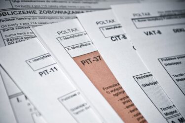 Polskie formularze podatkowe - PIT-37, PIT-11, CIT-8 I VAT-8 -leżą na stosie papierów