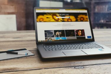 Nowoczesna strona internetowa wyświetlona na laptopie leżącym na drewnianym biurku