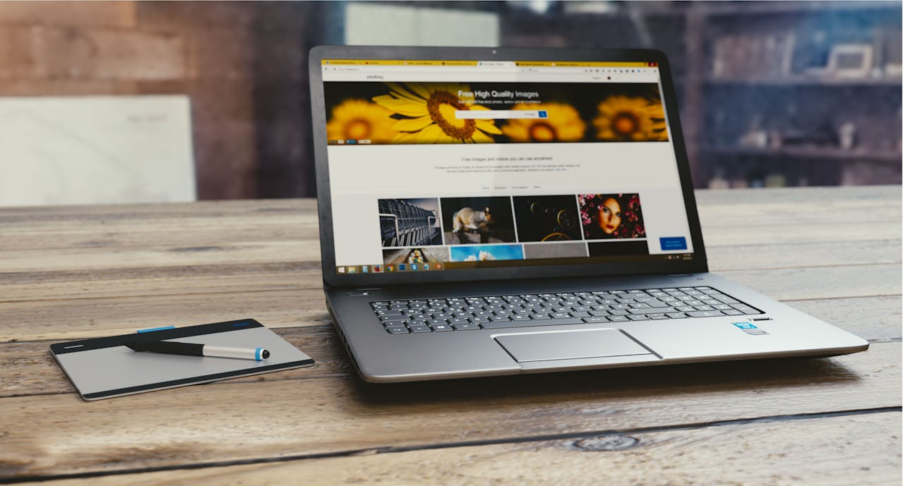 Nowoczesna strona internetowa wyświetlona na laptopie leżącym na drewnianym biurku
