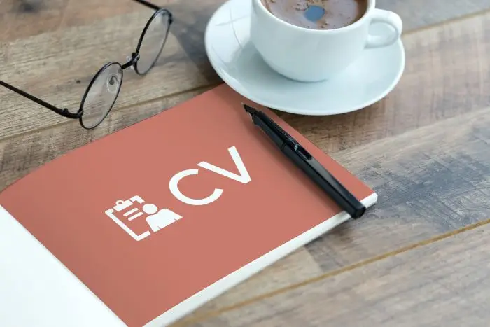 wzory cv - dokument z napisem cv położony na blacie obok kawy