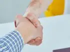 Umowa o dzieło - zbliżenie da dłonie dwóch osób w uścisku