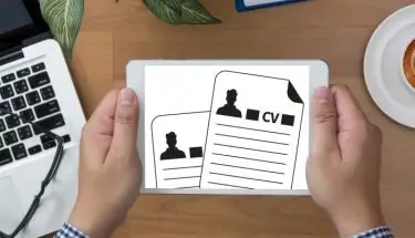 Mężczyzna trzymający tablet z grafikami CV na ekranie
