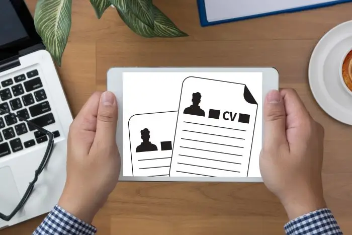 Mężczyzna trzymający tablet z grafikami CV na ekranie