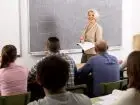 Nauczycielka przed słuchaczami w sali, przy tablicy