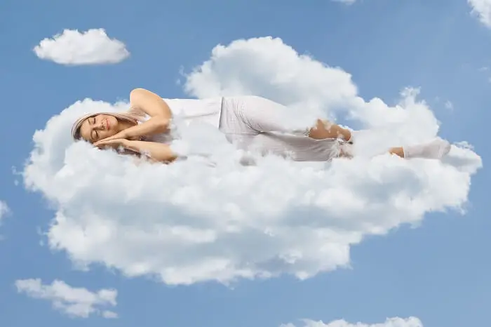 Jak się wyspać - kobieta śpiąca na chmurze