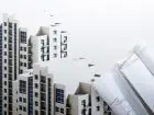 Leasing nieruchomości - makieta budynku, obok plan budowy