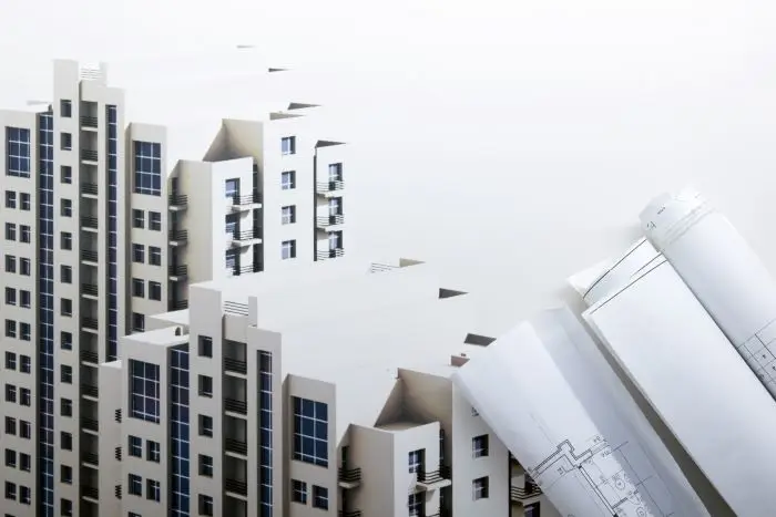 Leasing nieruchomości - makieta budynku, obok plan budowy