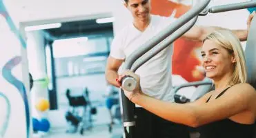 Multisport - kobieta ćwicząca na siłowni z trenerem personalnym