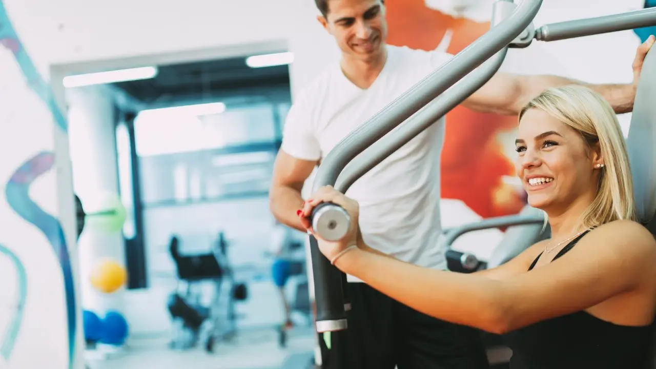 Multisport - kobieta ćwicząca na siłowni z trenerem personalnym