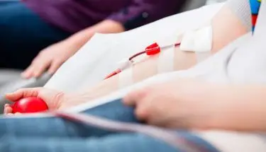 Oddawanie krwi - dłoń w trakcie pobierania krwi