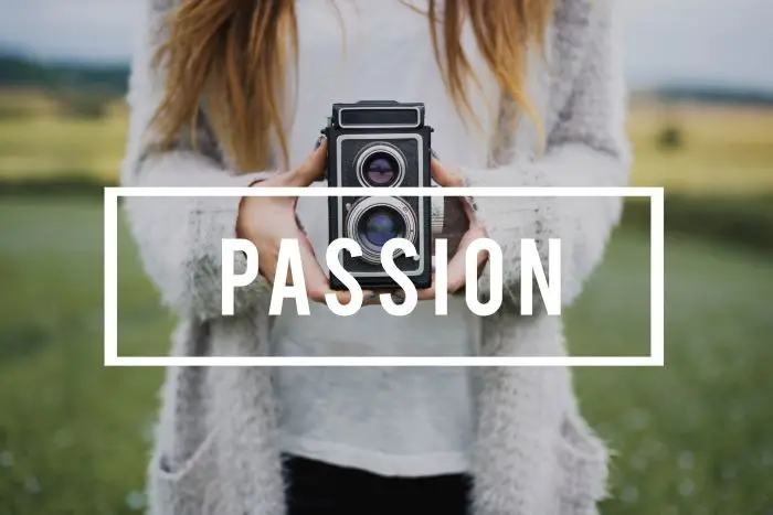 Pasja w CV - zdjęcie kobiety z aparatem na tle napisu passion