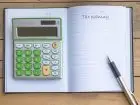 Zeszyt z napisem "tax planing" i położony na nim kalkulator