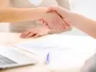 Umowa przedwstępna - uścisk dłoni dwóch osób nad dokumentem