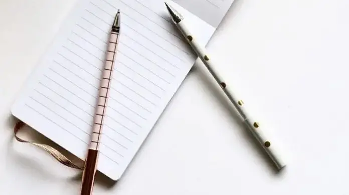 Wniosek o urlop bezpłatny - notes i dwa długopisy na stole