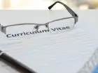 Okualry położone na kartce podpisanej "curriculum vitae"