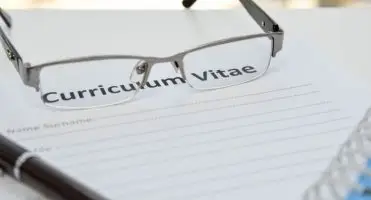 Okualry położone na kartce podpisanej "curriculum vitae"