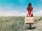 Au pair - kobieta z walizką na drodze