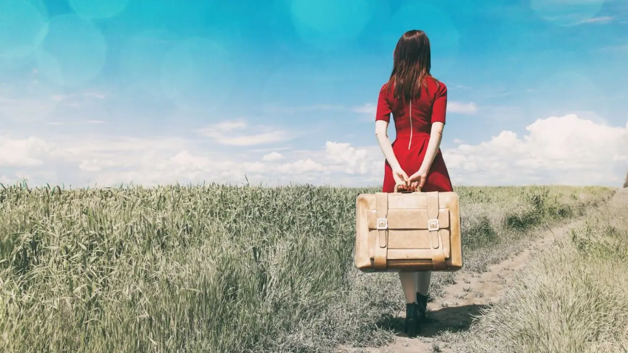 Au pair - kobieta z walizką na drodze