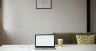 Laptop i kawa na biurku w mieszkaniu