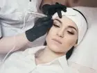 Kosmetolog wykonujący makijaż permanentny klientce