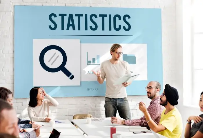 Kwartyle wynagrodzenia - spotkanie osób, napis "statistics" na tablicy