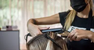 Fryzjer ciągnie klienta za włosy, po umyciu głowy, nałożeniu na włosy odżywek i wysuszeniu włosów