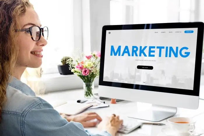 Psycholog reklamy - kobieta siedząca przed ekranem komputera z napisem "marketing"