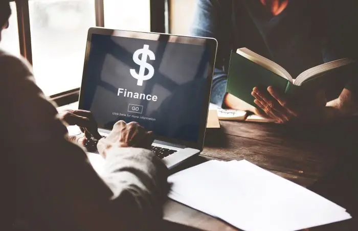 Osoba korzystająca z laptopa z napisem na ekranie "finance"