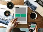 Specjalista UX - osoba pracująca przy biurku na tablecie nad umiejscowieniem elementów na stronie
