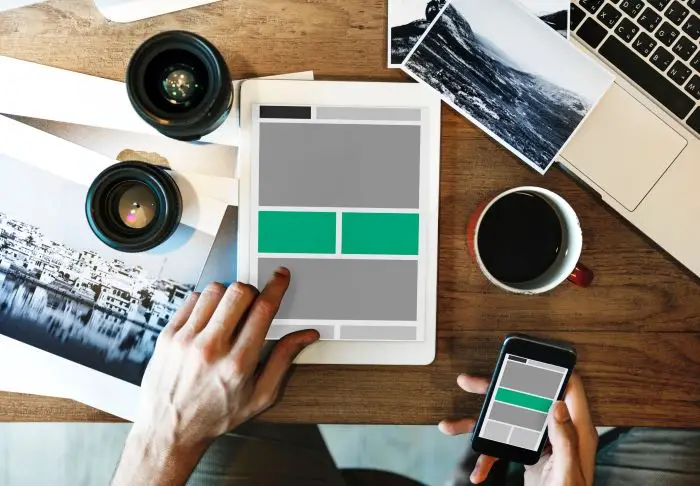 Specjalista UX - osoba pracująca przy biurku na tablecie nad umiejscowieniem elementów na stronie