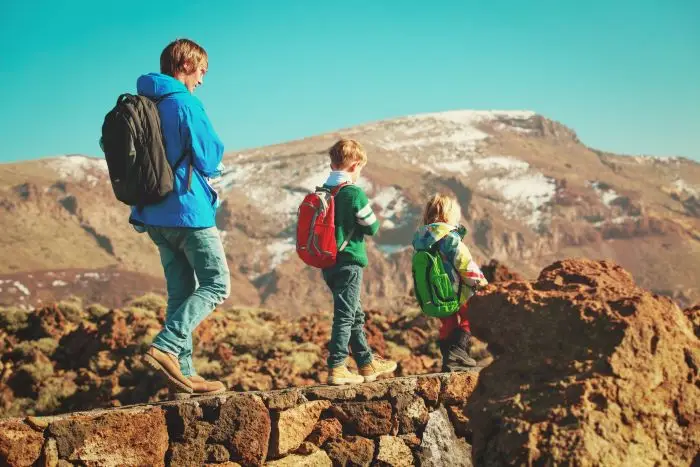 Dzieci spacerujące po górach z opiekunem