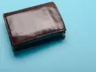 Zamknięty portfel na niebieskim tle