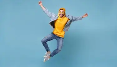 Entuzjazm - entuzjastyczny pracownik skacze z radości na niebieskim tle