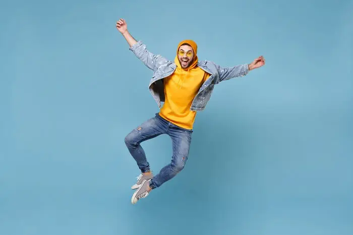 Entuzjazm - entuzjastyczny pracownik skacze z radości na niebieskim tle