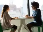 dwie kobiety rozmawiają ze sobą w kawiarni i prowadzą rozmowę o pracę