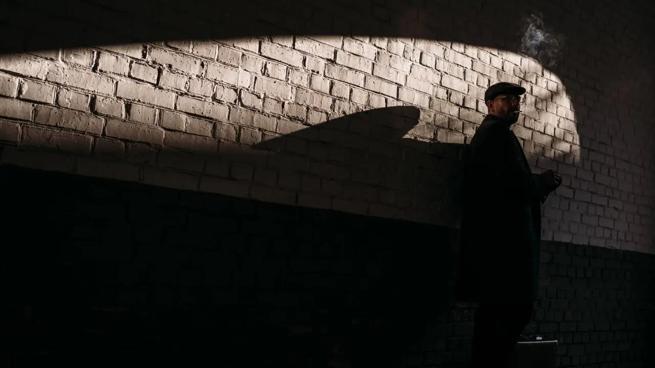 Wampir energetyczny w pracy - mężczyzna w długim płaszczu na ciemnym tle