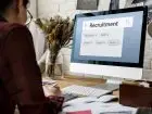 Assessment Center - osoba pracująca przy komputerze, na ekranie napis "recruitment"