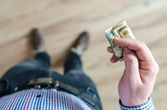 mężczyzna trzymający pieniądze w banknotach