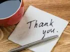 Kawa na blacie, obok chusteczka z napisem "thank you"