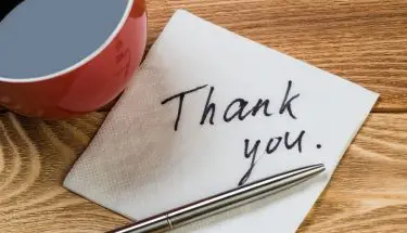 Kawa na blacie, obok chusteczka z napisem "thank you"