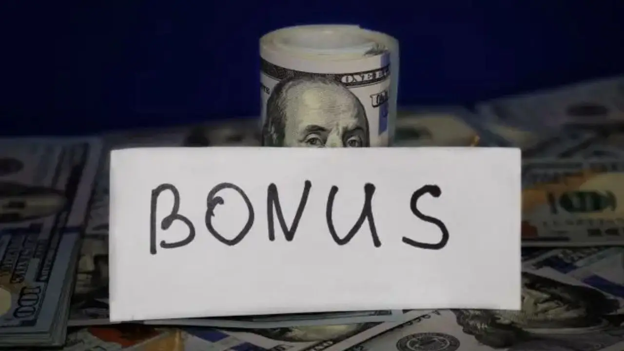 Premia dla pracownika - napis bonus na tle banknotów dolarów