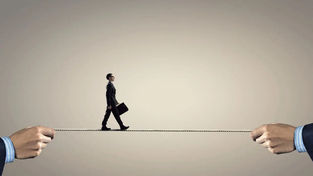 Skutki bezrobocia w Polsce - pracownik idący po linie
