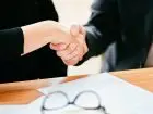 Umowa na czas próbny - osoby ściskające sobie dłonie nad umową