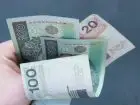 Banknoty polskie w dłoni na ciemnym tle