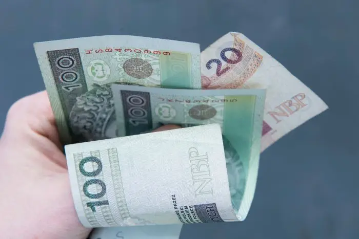 Banknoty polskie w dłoni na ciemnym tle