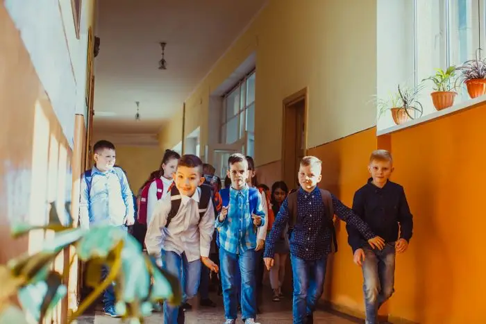 Dzieci biegnące przez korytarz w szkole